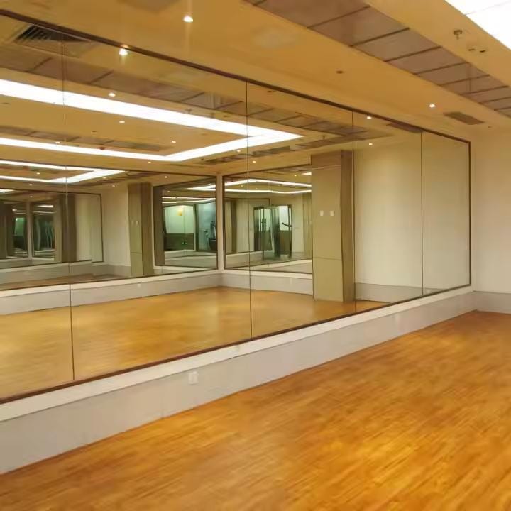Full wall mirror in a studio with wood floor