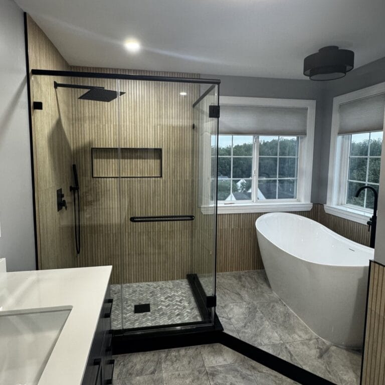 Modern bathroom featuring a glass walk-in shower with vertical wood-slat tiles, a freestanding tub, and black fixtures